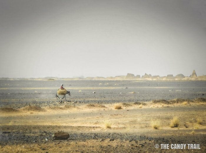 man-on-donkey in desert near meroe-pyramids sudan