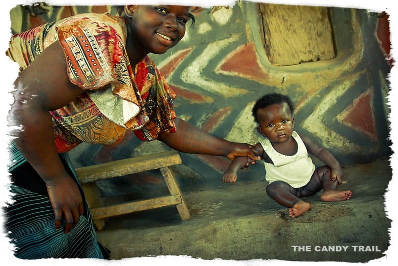 Woman and baby at painted houses of Ghana in Sirigu village.