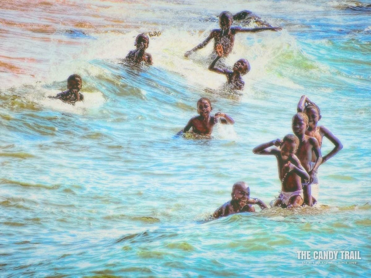 boys play about in surf at ulisa bay lake malawi