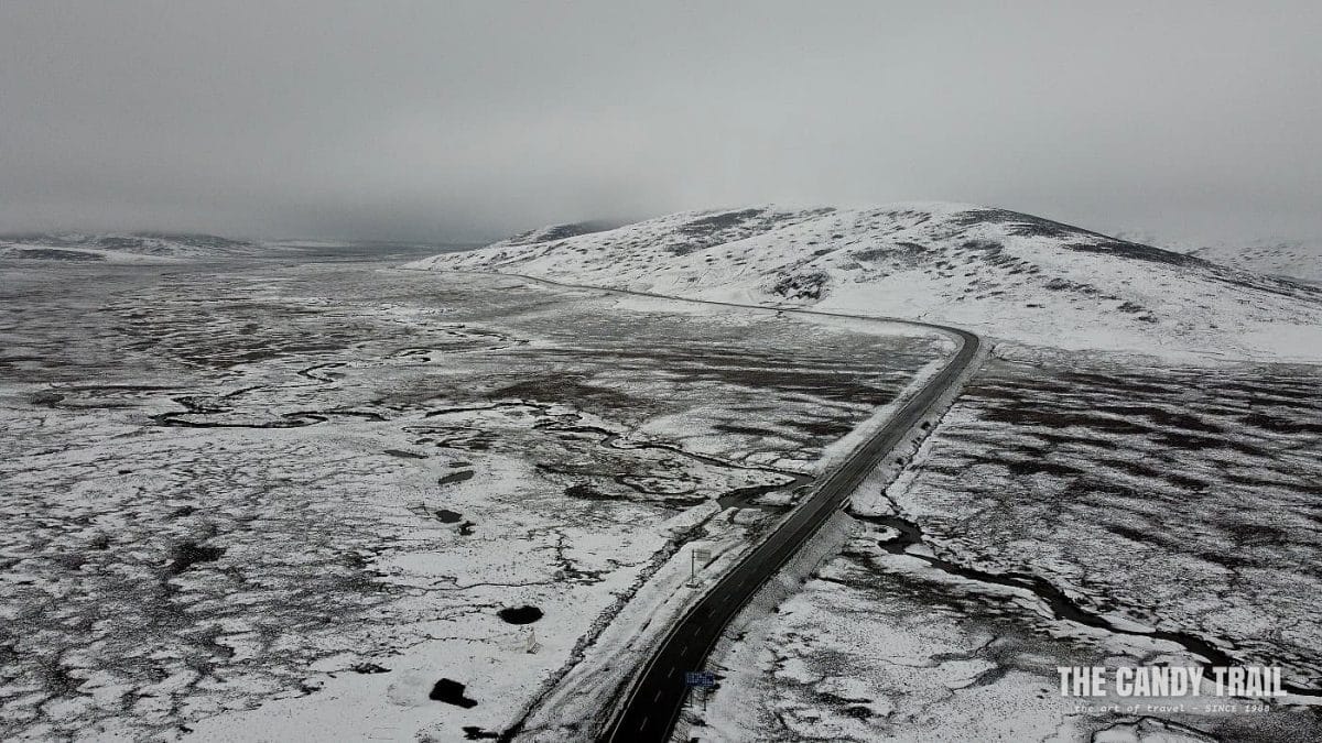 Deserted road on snowy Galitai Mountain Pass - China.