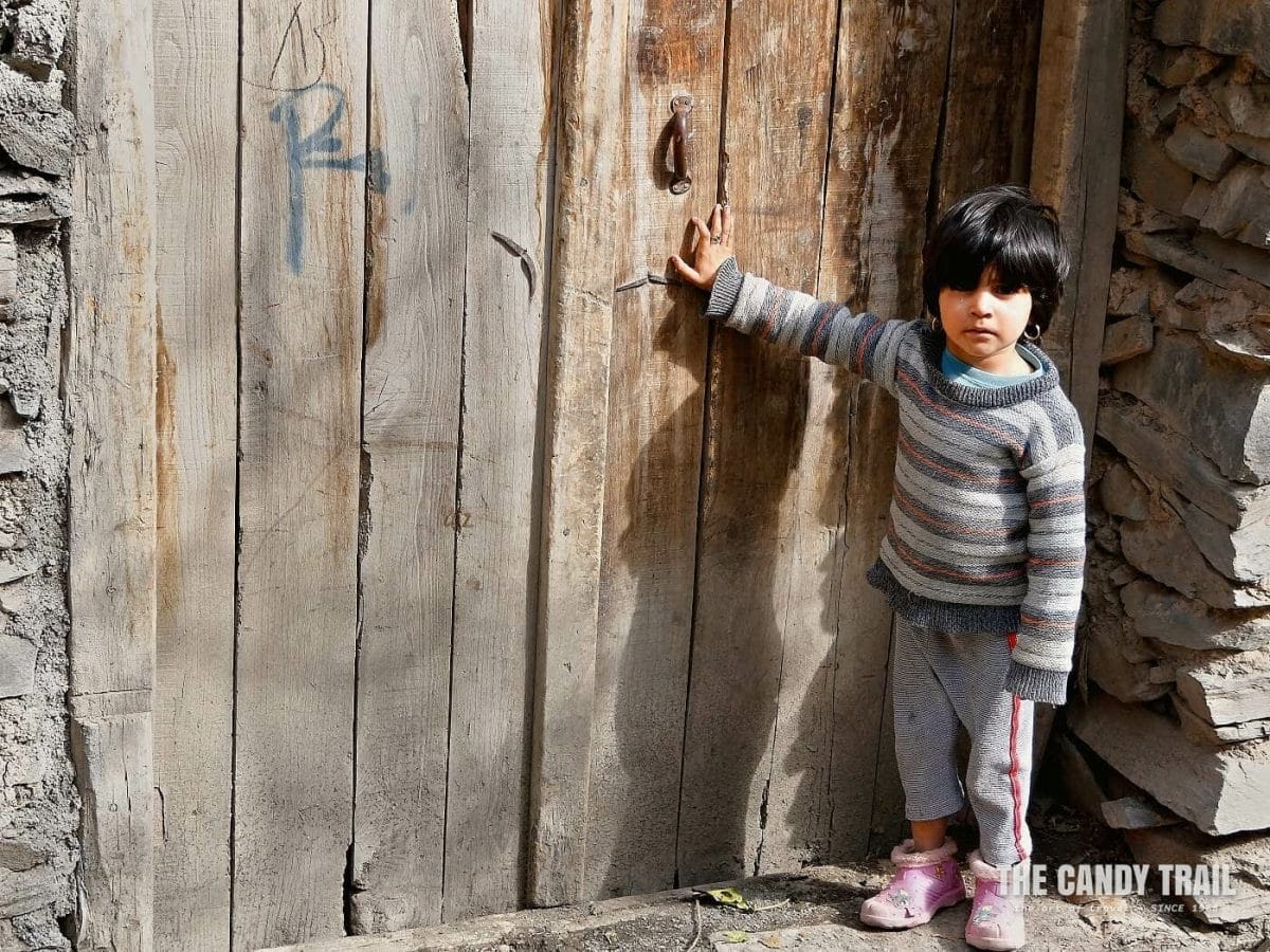 young girl at door kang village iran