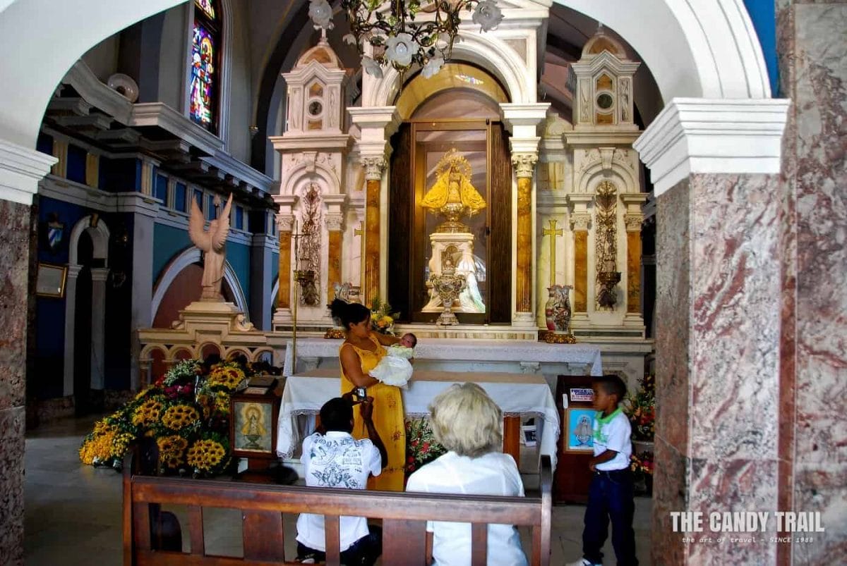 Family with baby pose at the altar of Basilica de Nuestra Señora del Cobre