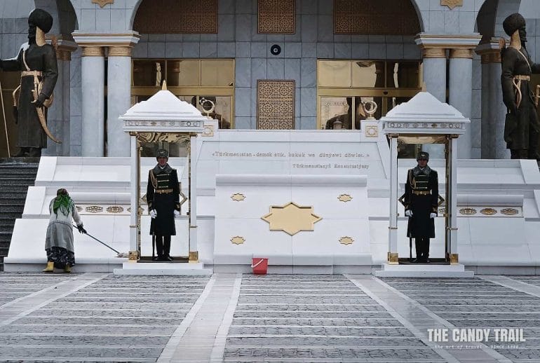 Guards at Independence monument in their sentry boxes and women cleans the marble around them ashgabat turkmenistan