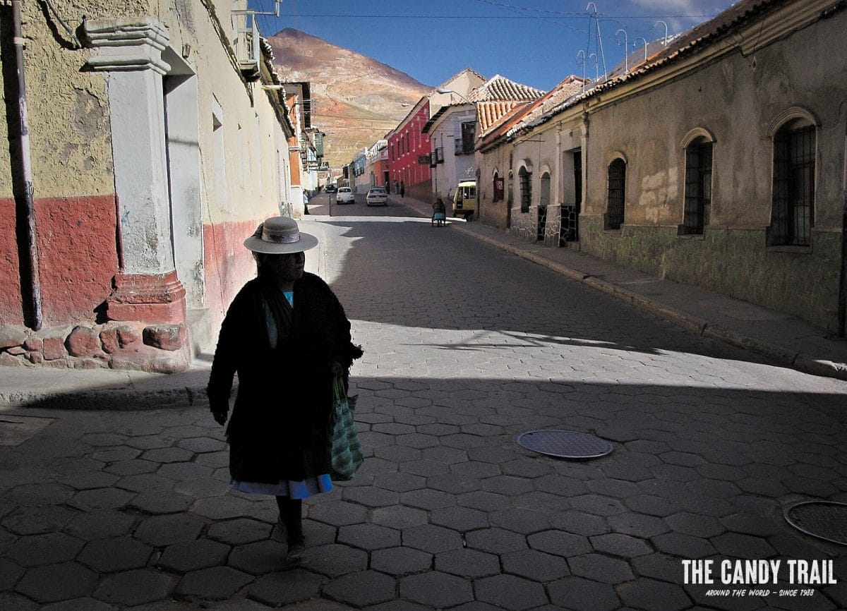 Indigenous Andean woman in the quiet backstreets of Potosi in Bolivia